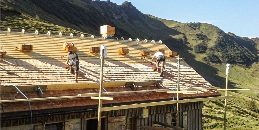 Arbeiter das Hausdach am Schindeln
